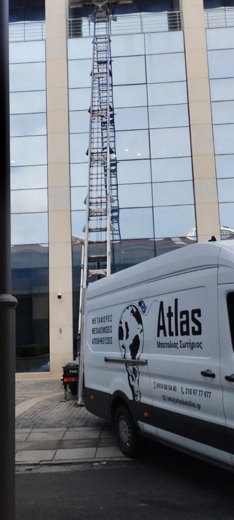 Ανυψωτικό μηχάνημα σε μετακόμιση γραφείων σε κτίριο με γυάλινη πρόσοψη